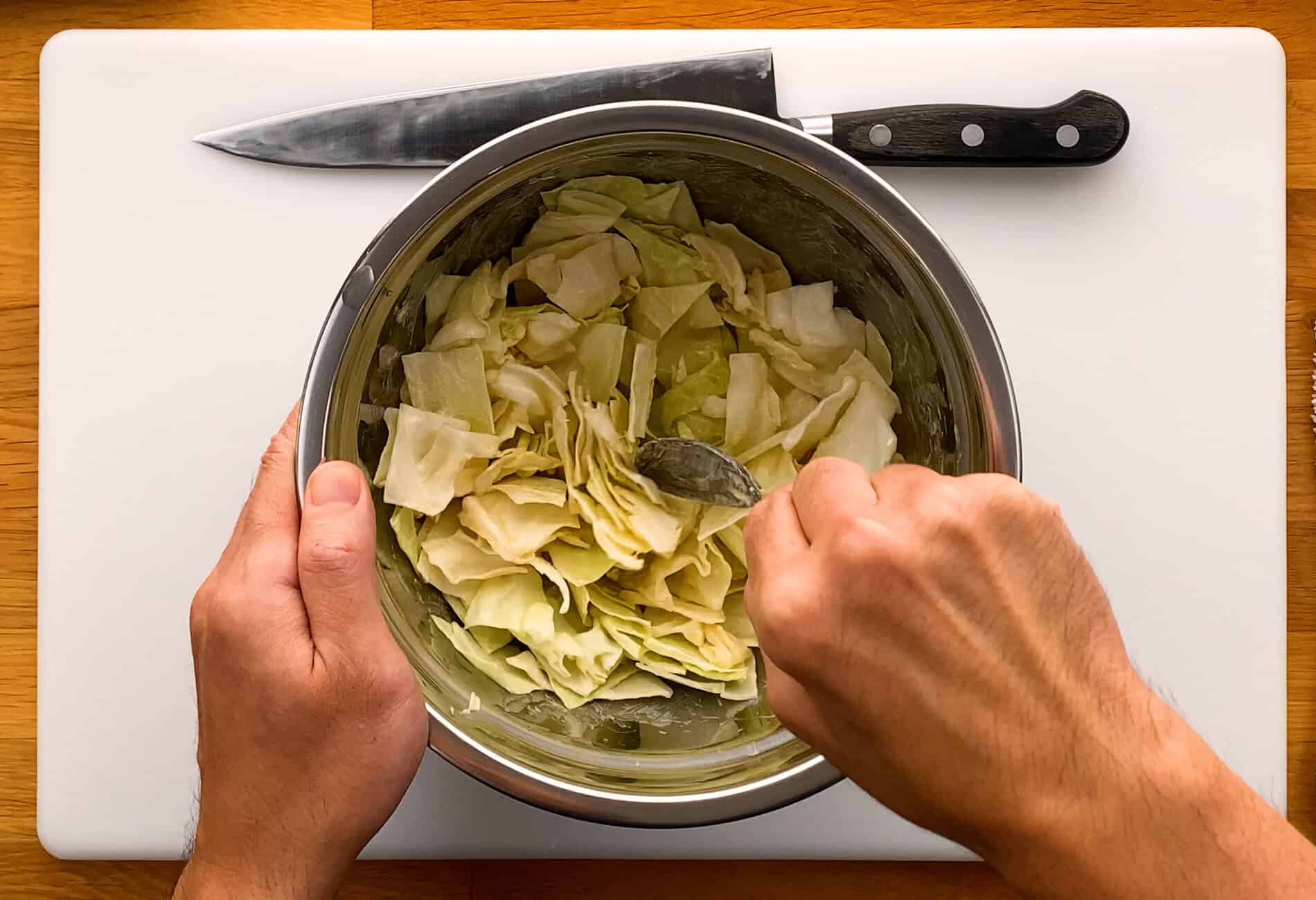Mixing chopped cabbage with mayonnaise and sesame oil