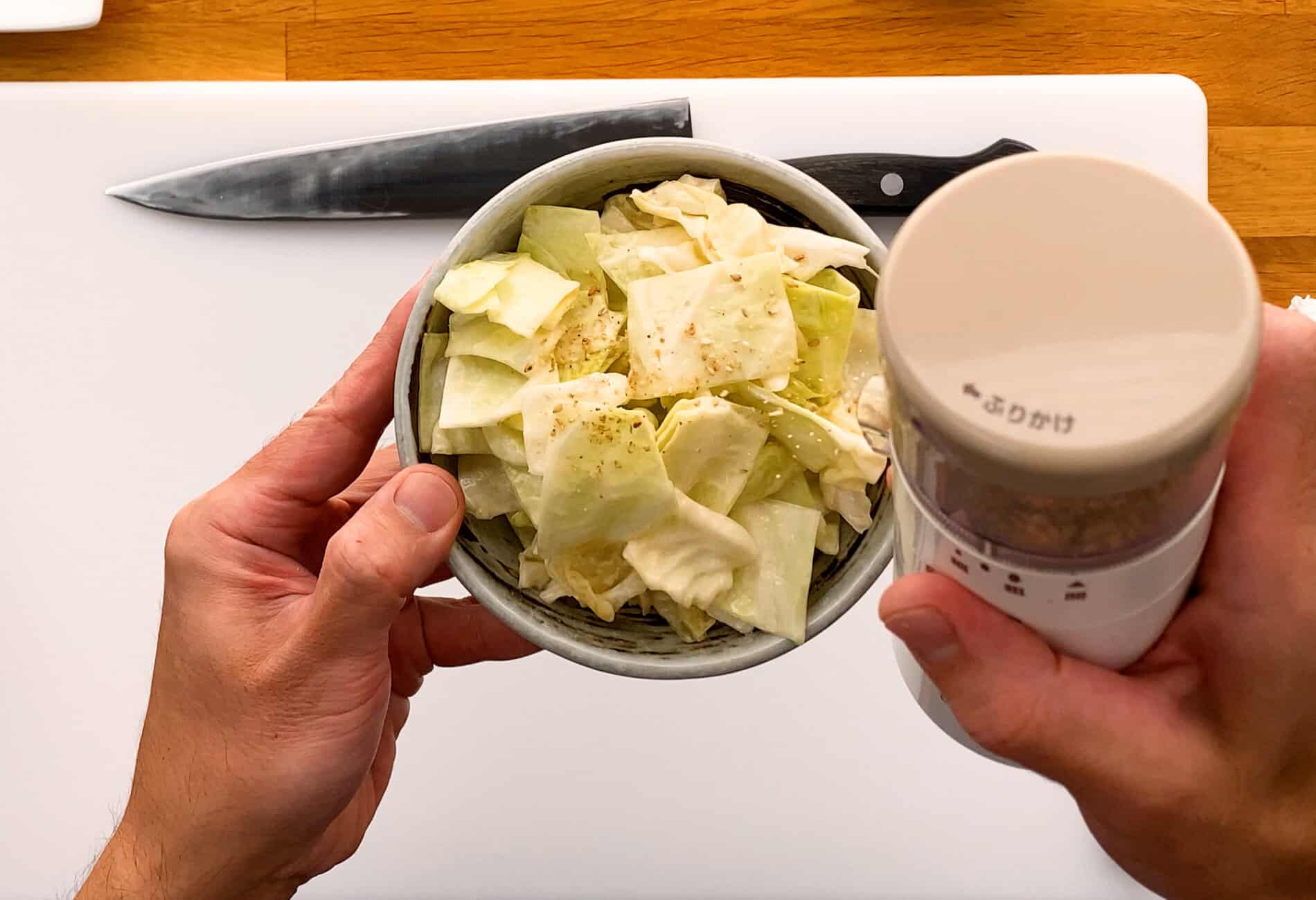 Grinding sesame seeds on top of cabbage salad