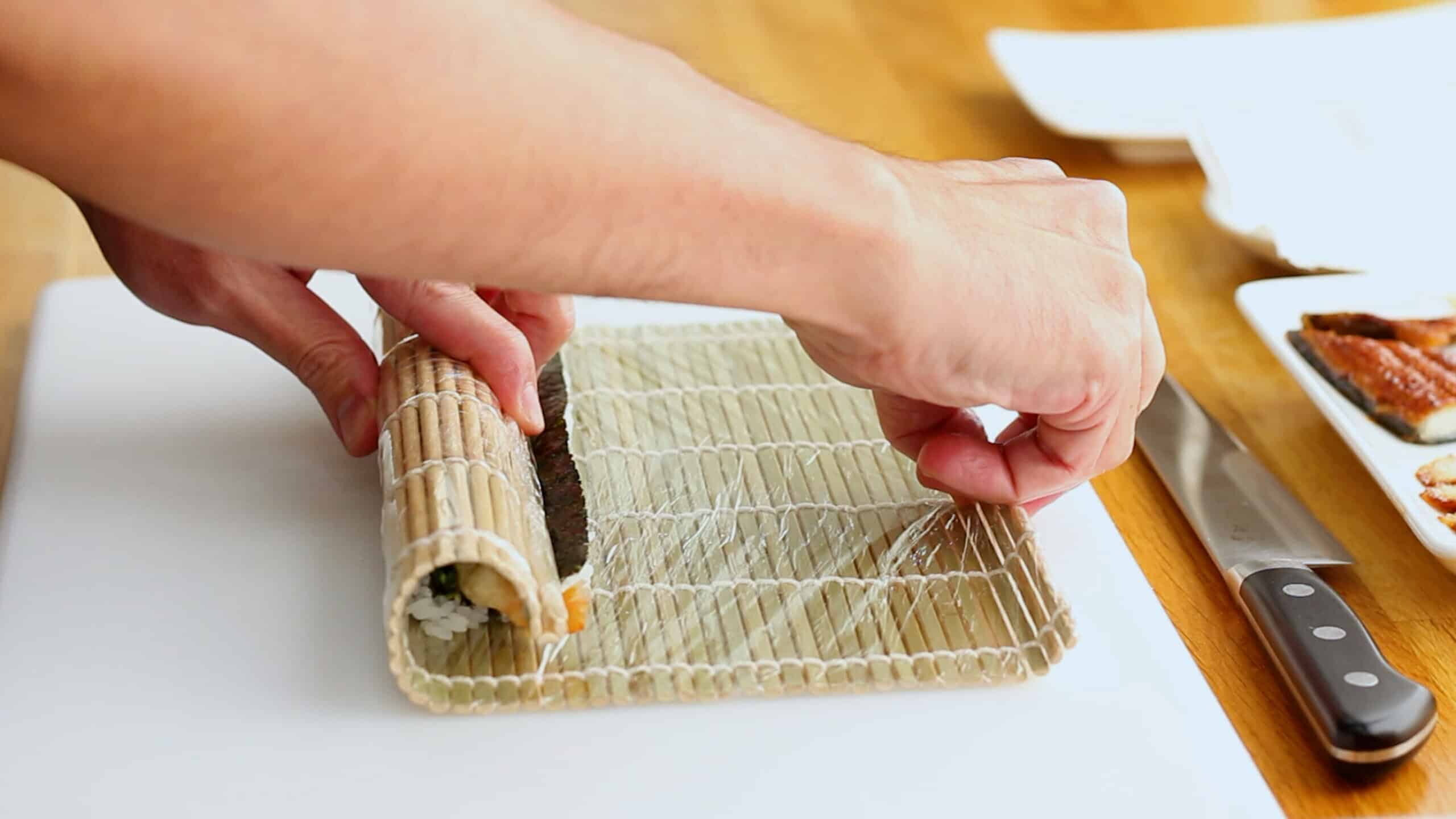 Makisu bamboo sushi mat tightening a sushi roll