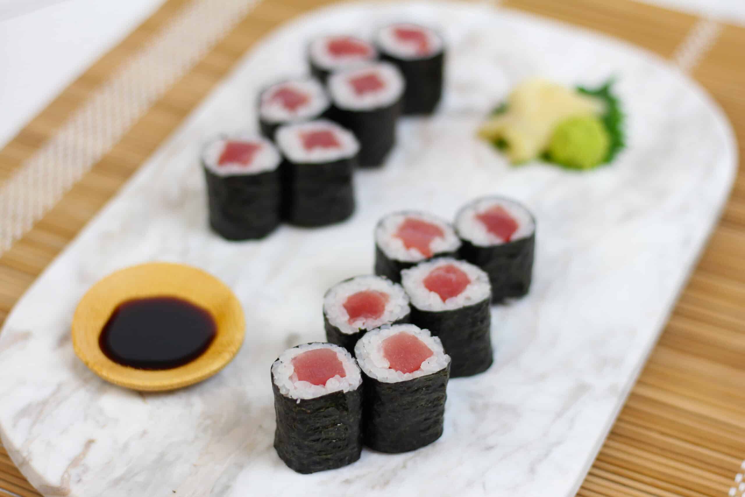 Tekkamaki tuna roll sushi with soy sauce, ginger, and wasabi