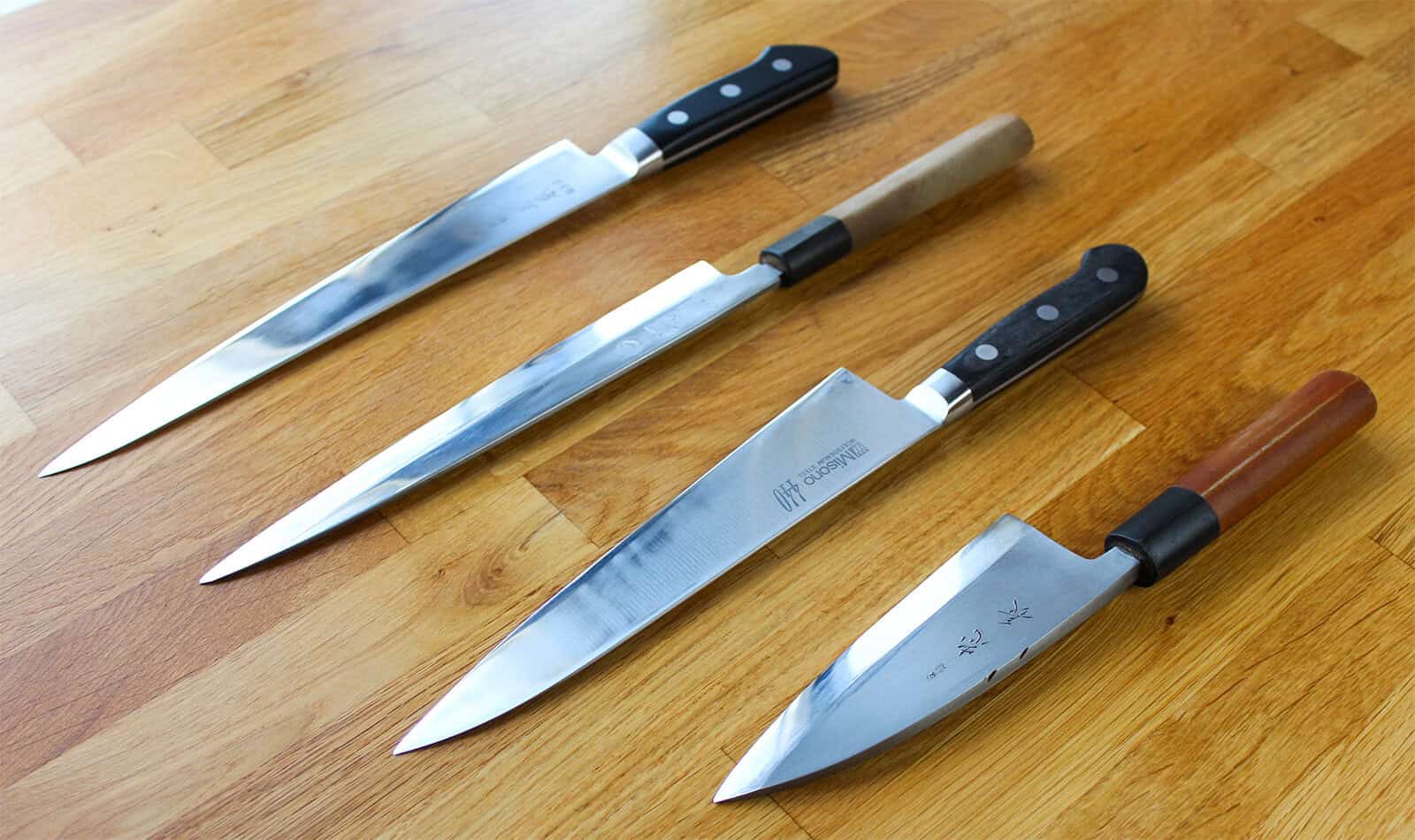 Four Japanese knives commonly used for sushi, including a yanagiba, sujihiki, gyuto, and deba.